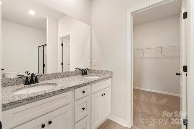 1060 Russell Dr, Winston Salem, NC 27127 - full bath featuring double vanity, a walk in closet, and a stall shower