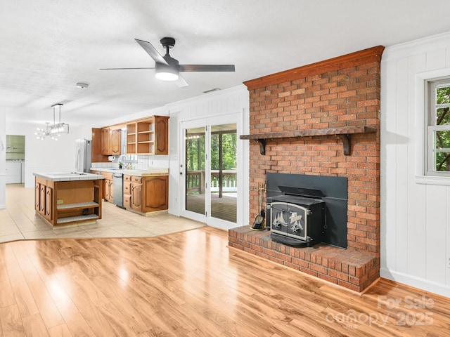 8 Mayfair Dr, Candler, NC 28715 - unfurnished living room featuring a wood stove, light wood-style flooring, healthy amount of natural light, and crown molding