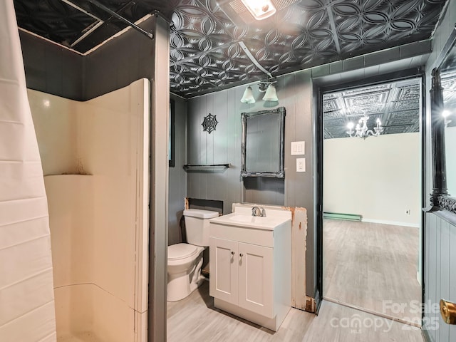 8 Mayfair Dr, Candler, NC 28715 - bathroom featuring wood finished floors, vanity, an ornate ceiling, a shower, and a baseboard heating unit