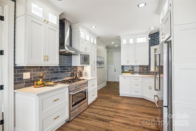 5985 Natoma Rd, Clover, SC 29710 - kitchen with appliances with stainless steel finishes, wall chimney exhaust hood, tasteful backsplash, white cabinets, and dark wood-style flooring