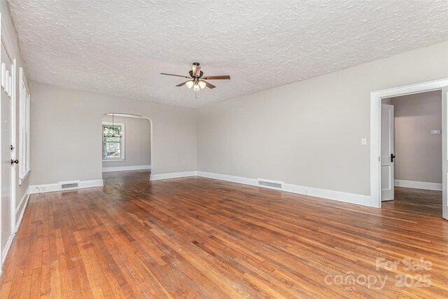 309 E Main St, Lattimore, NC 28089 - unfurnished room featuring ceiling fan, hardwood / wood-style flooring, a textured ceiling, and arched walkways