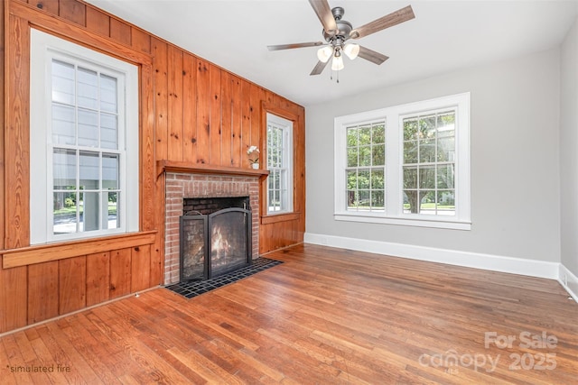 309 E Main St, Lattimore, NC 28089 - unfurnished living room featuring wood finished floors, wooden walls, a brick fireplace, and ceiling fan
