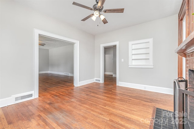 309 E Main St, Lattimore, NC 28089 - unfurnished living room featuring ceiling fan, a brick fireplace, wood finished floors, and built in features