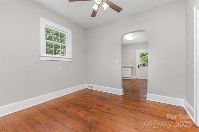 309 E Main St, Lattimore, NC 28089 - empty room with arched walkways, ceiling fan, and wood finished floors