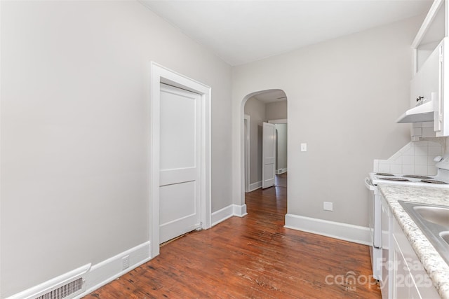 309 E Main St, Lattimore, NC 28089 - kitchen with white range with electric stovetop, arched walkways, white cabinets, light countertops, and dark wood finished floors