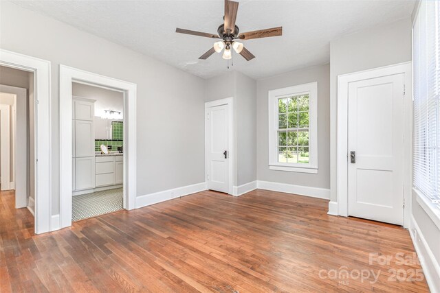 309 E Main St, Lattimore, NC 28089 - unfurnished bedroom featuring wood finished floors, connected bathroom, and ceiling fan