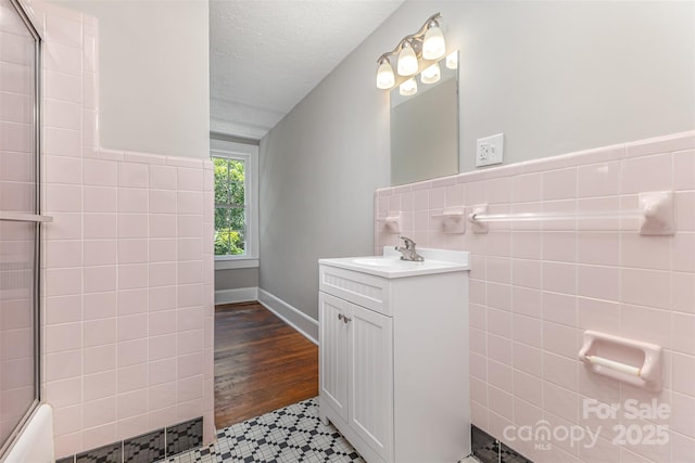 309 E Main St, Lattimore, NC 28089 - bathroom with vanity, tile walls, tile patterned flooring, and enclosed tub / shower combo