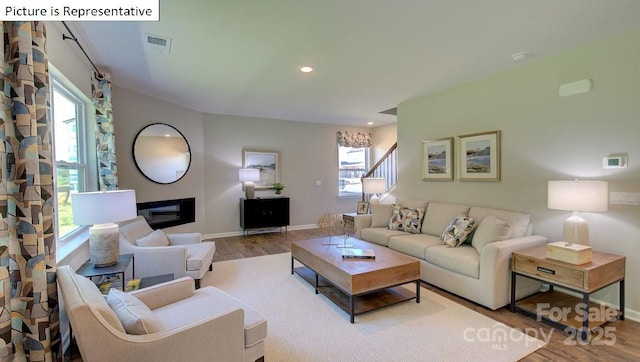 1400 Secrest Commons Dr, Monroe, NC 28112 - living area featuring wood finished floors, plenty of natural light, a glass covered fireplace, recessed lighting, and stairway