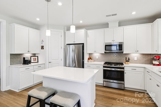 3022 Trace Meadow Ct, York, SC 29745 - kitchen featuring appliances with stainless steel finishes, decorative backsplash, a kitchen bar, a kitchen island, and white cabinets
