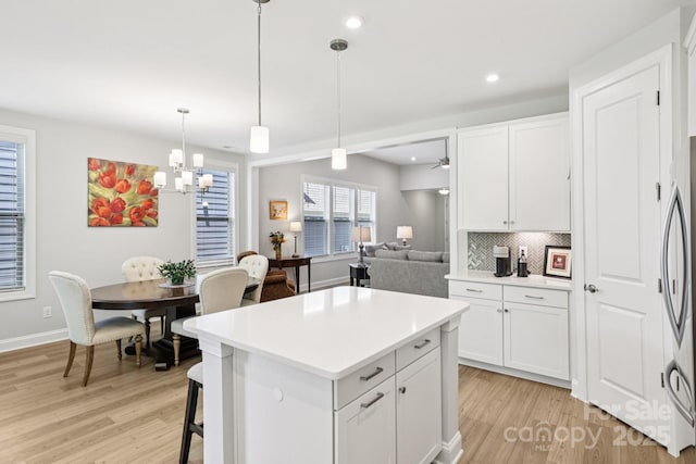 3022 Trace Meadow Ct, York, SC 29745 - kitchen featuring light wood-type flooring, tasteful backsplash, light countertops, white cabinets, and a center island