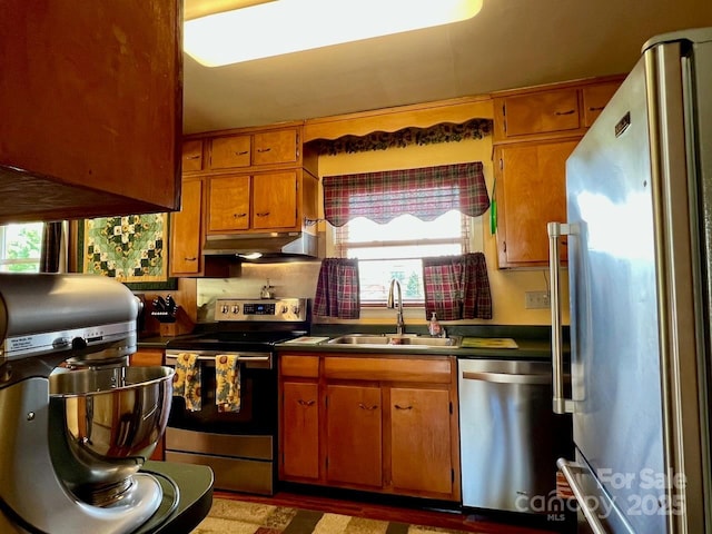 795 Monte Vista Rd, Candler, NC 28715 - kitchen featuring stainless steel appliances, under cabinet range hood, dark countertops, and brown cabinetry