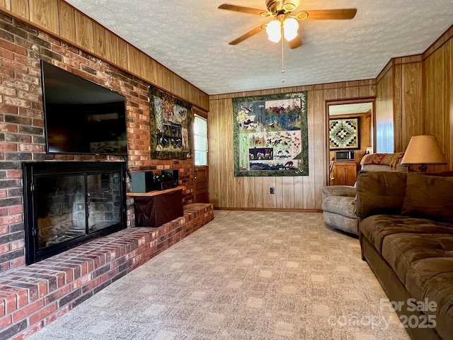 795 Monte Vista Rd, Candler, NC 28715 - living room featuring a textured ceiling, a fireplace, wooden walls, and ceiling fan