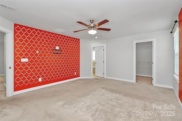 7079 Waterwheel St SW, Concord, NC 28025 - unfurnished bedroom featuring an accent wall, a spacious closet, carpet, a closet, and a ceiling fan
