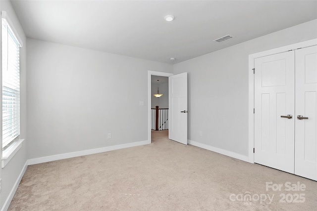 7079 Waterwheel St SW, Concord, NC 28025 - unfurnished bedroom with light carpet, multiple windows, and a closet