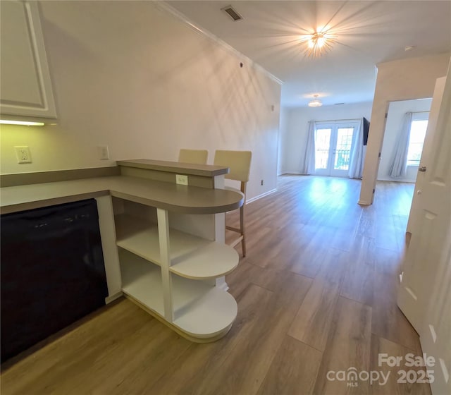 1410 4th Street Dr NW Unit 303, Hickory, NC 28601 - kitchen with black dishwasher, wood finished floors, open floor plan, open shelves, and a peninsula