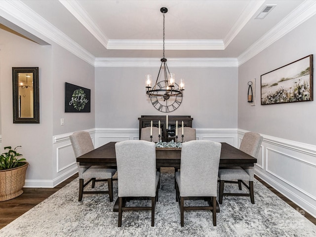 2005 Arbor Hills Dr, Indian Trail, NC 28079 - dining space with a chandelier, dark wood-type flooring, a raised ceiling, crown molding, and a wainscoted wall