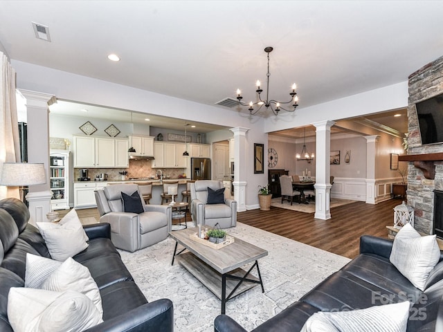 2005 Arbor Hills Dr, Indian Trail, NC 28079 - living room featuring ornate columns, a chandelier, a wainscoted wall, a decorative wall, and wood finished floors