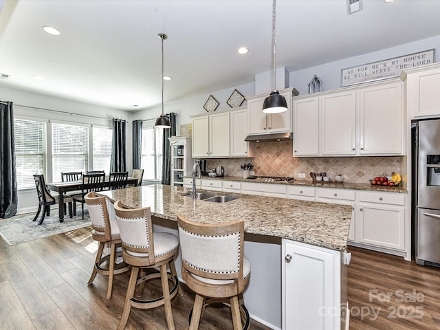2005 Arbor Hills Dr, Indian Trail, NC 28079 - kitchen featuring stainless steel appliances, dark wood finished floors, backsplash, a kitchen island with sink, and a breakfast bar area