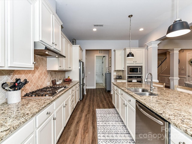 2005 Arbor Hills Dr, Indian Trail, NC 28079 - kitchen featuring appliances with stainless steel finishes, ornate columns, dark wood finished floors, under cabinet range hood, and white cabinetry