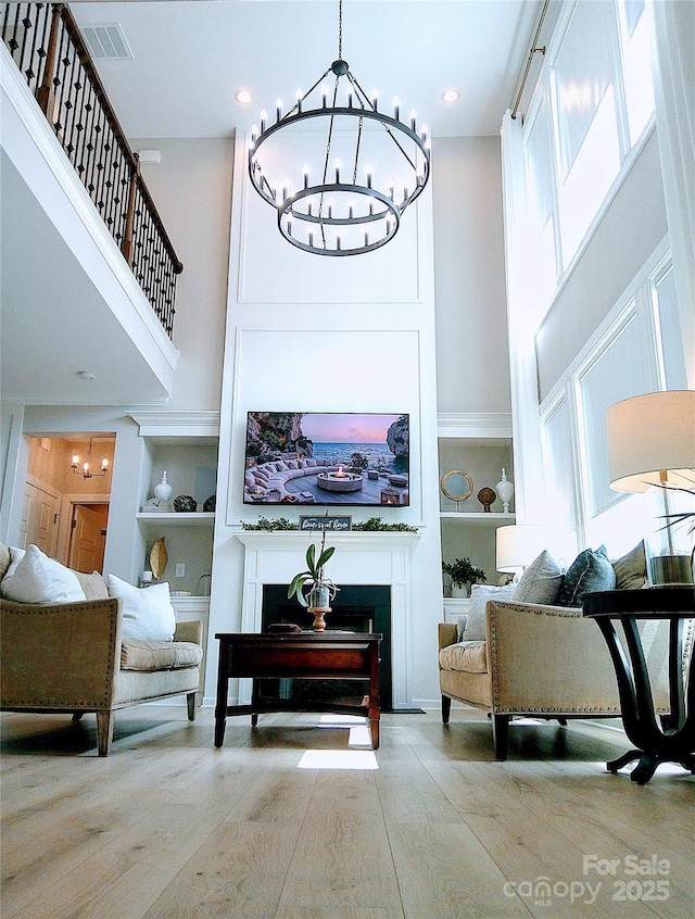1141 Overlake Dr, Belmont, NC 28012 - sitting room with a towering ceiling, a chandelier, wood finished floors, a fireplace, and built in features