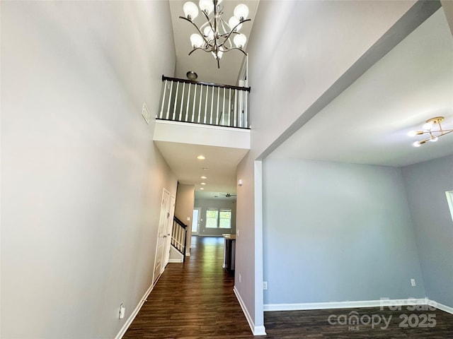 11109 Pond Valley Ct, Charlotte, NC 28269 - hallway featuring stairway, dark wood-style flooring, a chandelier, and a towering ceiling