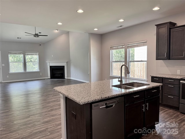 11109 Pond Valley Ct, Charlotte, NC 28269 - kitchen with stainless steel appliances, dark wood-type flooring, ceiling fan, a fireplace, and a kitchen island with sink