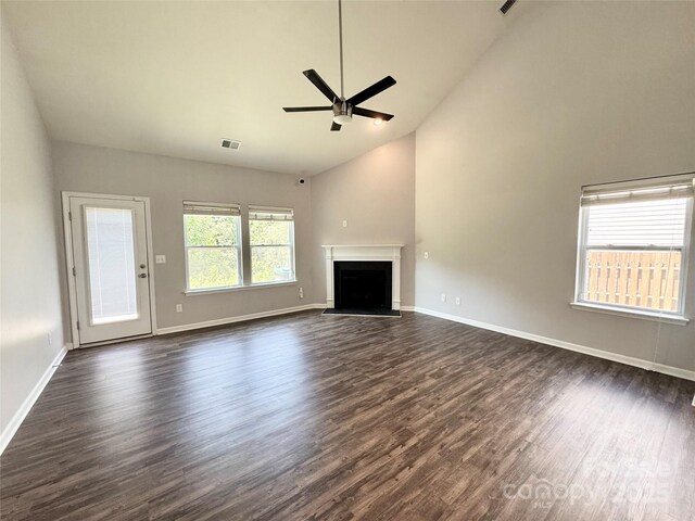 11109 Pond Valley Ct, Charlotte, NC 28269 - unfurnished living room featuring ceiling fan, dark wood-style flooring, a fireplace with raised hearth, and high vaulted ceiling