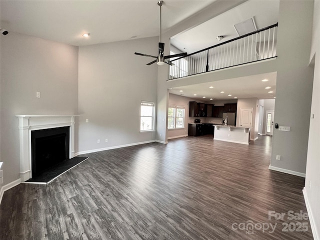 11109 Pond Valley Ct, Charlotte, NC 28269 - unfurnished living room with a ceiling fan, dark wood-style floors, high vaulted ceiling, a fireplace with raised hearth, and recessed lighting