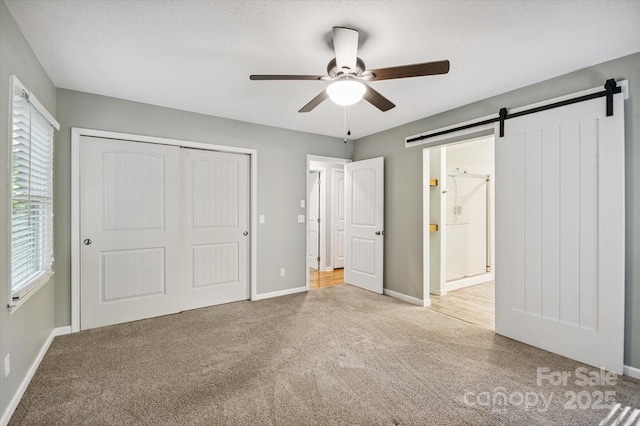 104 Britton Ave, Hendersonville, NC 28791 - unfurnished bedroom featuring carpet floors, a barn door, multiple windows, and a closet