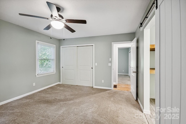 104 Britton Ave, Hendersonville, NC 28791 - unfurnished bedroom with carpet floors, a barn door, a ceiling fan, and a closet