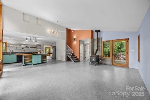 27 Rosebud Ln, Fairview, NC 28730 - unfurnished living room with a wood stove, high vaulted ceiling, healthy amount of natural light, and stairway