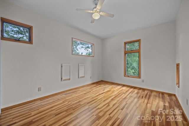 27 Rosebud Ln, Fairview, NC 28730 - unfurnished room featuring plenty of natural light, wood finished floors, and a ceiling fan