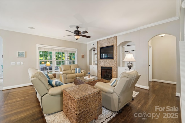 1237 Saint Johns Ave, Matthews, NC 28104 - living room featuring dark wood-style flooring, arched walkways, ceiling fan, built in features, and a tile fireplace