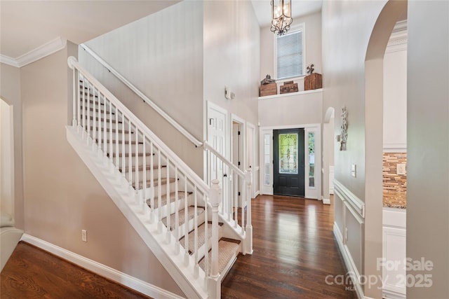 1237 Saint Johns Ave, Matthews, NC 28104 - foyer featuring arched walkways, dark wood-style floors, stairs, crown molding, and a high ceiling