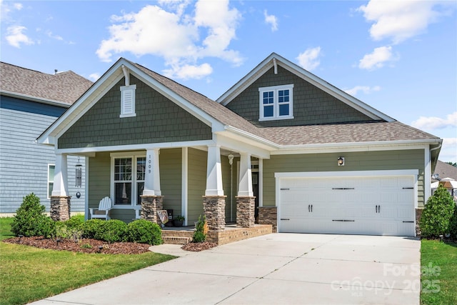 1009 Kemp Rd, Indian Trail, NC 28079 - craftsman-style house featuring covered porch, driveway, a garage, roof with shingles, and stone siding