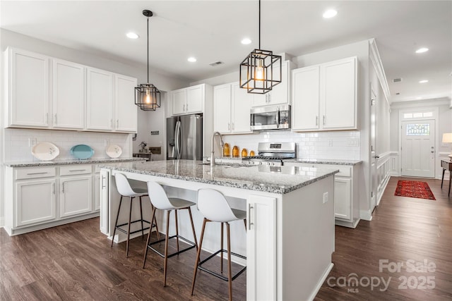 1009 Kemp Rd, Indian Trail, NC 28079 - kitchen with stainless steel appliances, backsplash, dark wood-type flooring, recessed lighting, and a kitchen island with sink