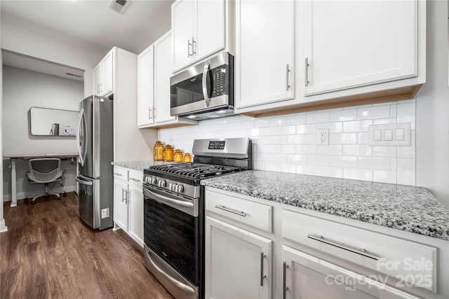 1009 Kemp Rd, Indian Trail, NC 28079 - kitchen featuring appliances with stainless steel finishes, dark wood-style flooring, light stone counters, and white cabinetry