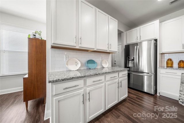 1009 Kemp Rd, Indian Trail, NC 28079 - kitchen with stainless steel refrigerator with ice dispenser, dark wood finished floors, backsplash, white cabinetry, and light stone countertops