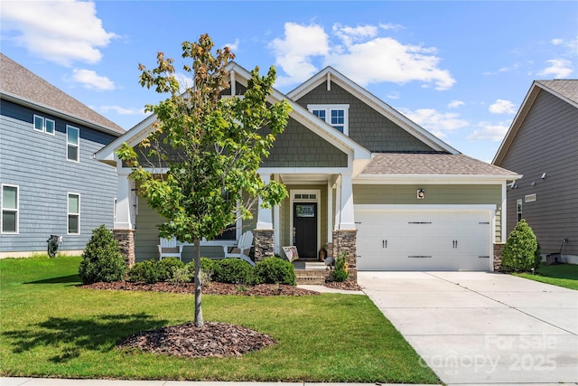 1009 Kemp Rd, Indian Trail, NC 28079 - craftsman house with a front lawn, covered porch, a garage, concrete driveway, and stone siding