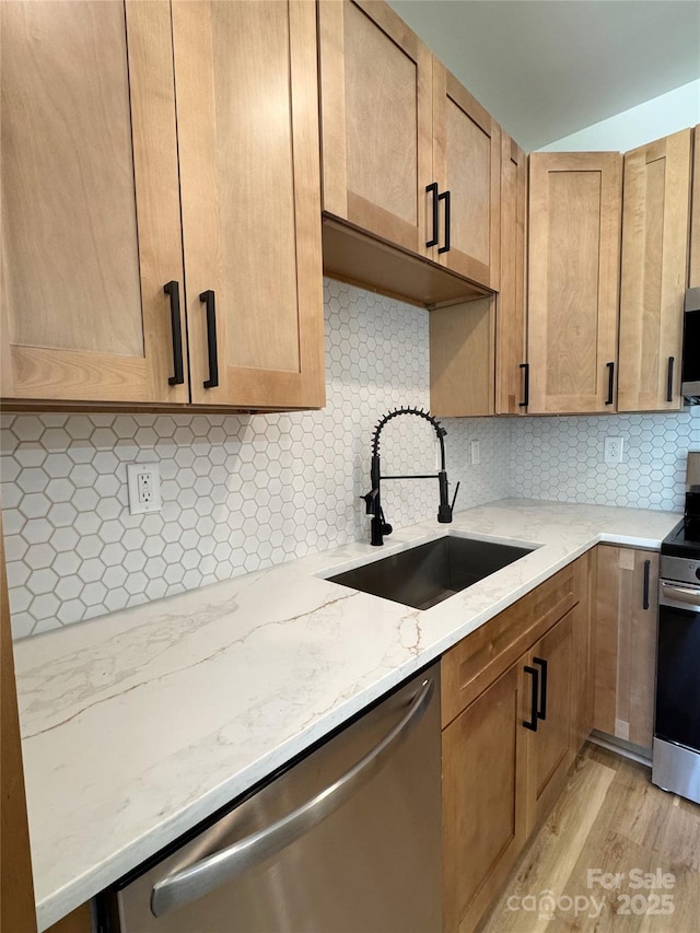 101 Bryan St, Kannapolis, NC 28083 - kitchen featuring appliances with stainless steel finishes, light stone counters, light wood-type flooring, and decorative backsplash