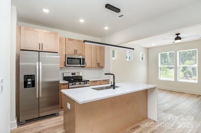 177 Georgia St SW, Concord, NC 28025 - kitchen with stainless steel appliances, light wood-style floors, backsplash, light countertops, and pendant lighting