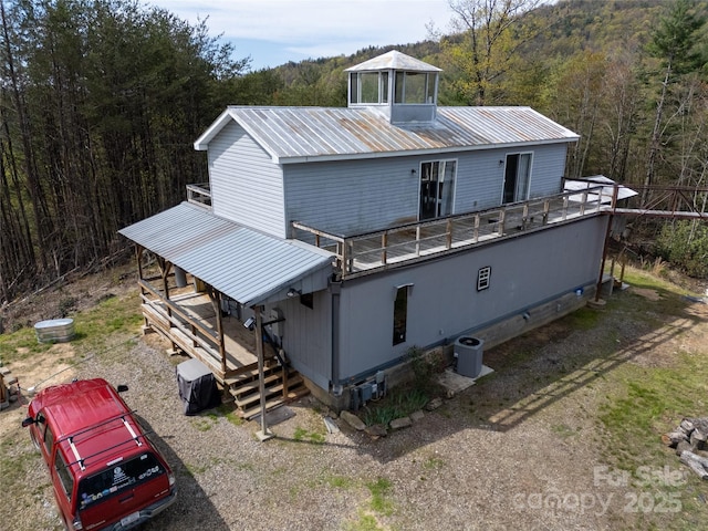 2668 Reedy Branch Rd, Purlear, NC 28665 - back of property with a metal roof, a wooded view, and a wooden deck