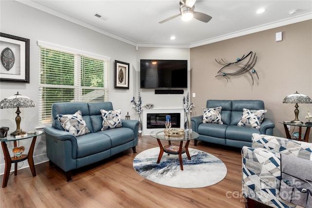 7516 Ohara St, Huntersville, NC 28078 - living room featuring a ceiling fan, wood finished floors, crown molding, recessed lighting, and a glass covered fireplace