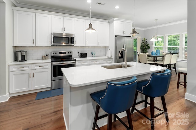 7516 Ohara St, Huntersville, NC 28078 - kitchen with stainless steel appliances, decorative backsplash, crown molding, a kitchen bar, and white cabinetry