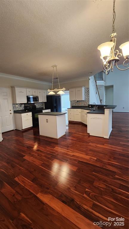 10607 Old Bridge Ln, Charlotte, NC 28269 - kitchen with black appliances, dark countertops, a chandelier, decorative backsplash, and a textured ceiling