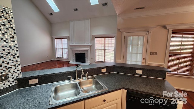 10607 Old Bridge Ln, Charlotte, NC 28269 - kitchen featuring wood finished floors, open floor plan, dark countertops, vaulted ceiling, and a fireplace