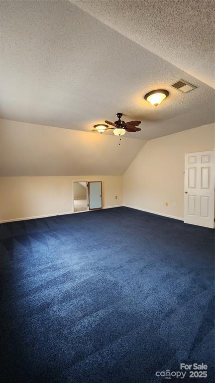 10607 Old Bridge Ln, Charlotte, NC 28269 - additional living space with lofted ceiling, a textured ceiling, dark carpet, and a ceiling fan