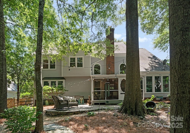 9141 Covey Hollow Ct, Charlotte, NC 28210 - back of house with a sunroom, a chimney, outdoor lounge area, and a patio
