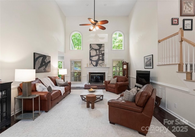 9141 Covey Hollow Ct, Charlotte, NC 28210 - living room with a high ceiling, a ceiling fan, a brick fireplace, stairs, and wood finished floors