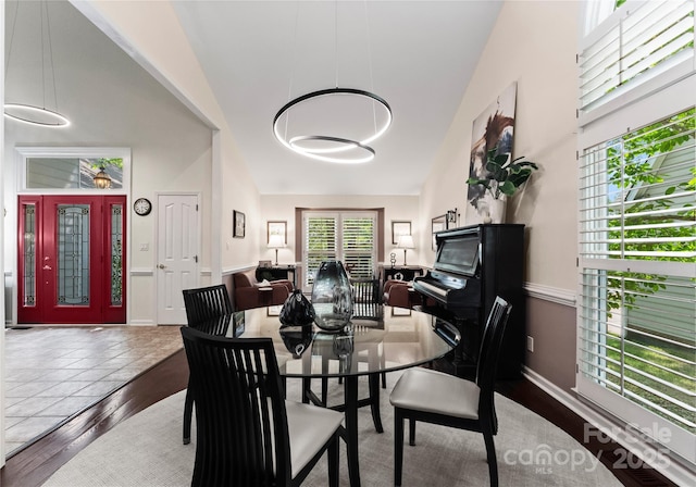 9141 Covey Hollow Ct, Charlotte, NC 28210 - dining area featuring healthy amount of natural light, wood finished floors, and high vaulted ceiling